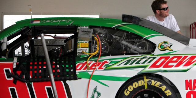 Dale Earnhardt Jr. peers out of the garage during NASCAR fuel-injection system testing at Daytona International Speedway in Daytona Beach, Fla., Tuesday, Nov. 15, 2011. (AP Photo/Daytona Beach News-Journal, Sean McNeil)
