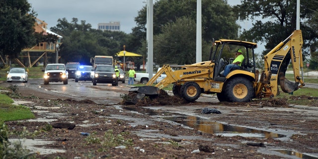 Biloxi public works employees clearing debris from U.S. 90 in Biloxi on Sunday.