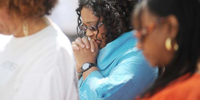 A woman prays in a church pew. Even when we're despairing, says one faith leader in South Carolina, we should not give up hope. God gives us strength. 