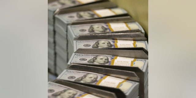 In this photo taken Sept. 24, 2013, just cut stacks of $100 bills make their way down the line at the Bureau of Engraving and Printing Western Currency Facility in Fort Worth, Texas. The nationâs health care tab is expected to surpass $10,000 per person for the first time this year, the government said Wednesday. The new peak suggests the Obama administration will pass the problem of high health care costs on to its successor. (AP Photo/LM Otero)