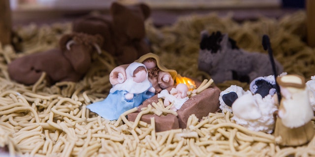 In the middle of the nativity, Mary, Joseph and baby Jesus sit surrounded by sheep, cows and the three wise men.