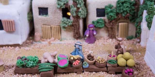 Two-inch-tall marzipan merchants sell goods on the display's busy main street.