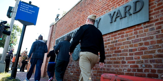 Employees of the Washington Navy Yard enter through a gate, many to retrieve their vehicles, two days after a gunman killed twelve people and was killed himself inside the Navy Yard in Washington, on Wednesday, Sept. 18, 2013.
