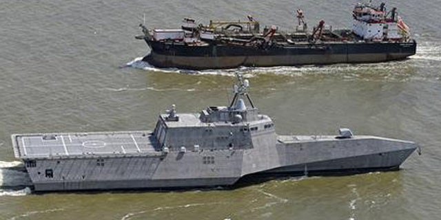 In this March 24, 2010, file photo, the littoral combat ship USS Independence, foreground, passes another vessel as it makes its way south through the waters of Mobile Bay, Ala.