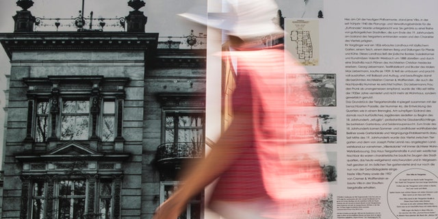 File photo - A woman walks past an information board showing a picture of the villa that served as the headquarters for Nazi Germany's "euthanasia" programme in Berlin, July 9, 2013. (REUTERS/Thomas Peter)
