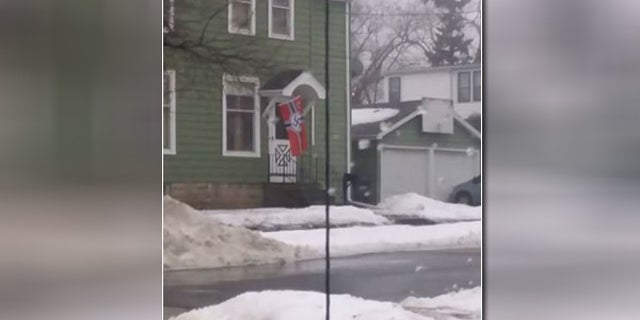 A family in Oshkosh, Wisc. says that this photo of their neighbor's Nazi flag created a firestorm after it went viral, leaving them no choice but to move after receiving numerous death threats.