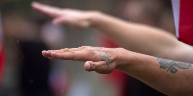 Members of a white supremacy group give the fascist salute during a gathering in West Allis, Wis., Sept. 3, 2011.