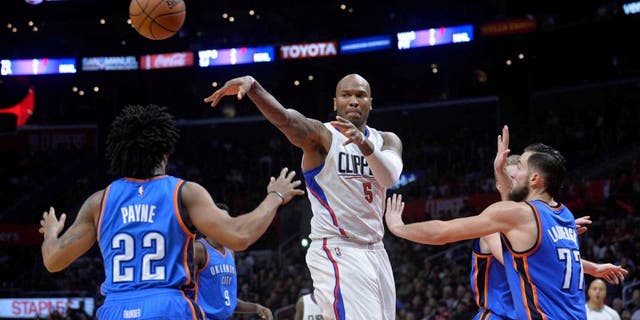 January 16, 2017; Los Angeles, CA, USA; Los Angeles Clippers center Marreese Speights (5) passes the ball against the defense of Oklahoma City Thunder guard Cameron Payne (22) and center Joffrey Lauvergne (77) during the second half at Staples Center. Mandatory Credit: Gary A. Vasquez-USA TODAY Sports