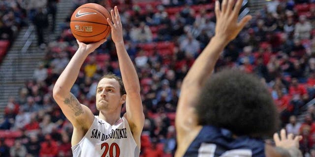 Jan 14, 2017; San Diego, CA, USA; San Diego State Aztecs forward Matt Shrigley (20) attempts a shot while defended by Utah State Aggies forward Jalen Moore (14) during the first half at Viejas Arena at Aztec Bowl. Mandatory Credit: Jake Roth-USA TODAY Sports
