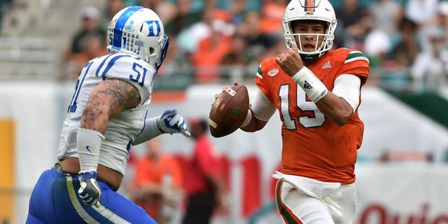 Nov 26, 2016; Miami Gardens, FL, USA; Miami Hurricanes quarterback Brad Kaaya (15) is pressured by Duke Blue Devils defensive end Dominic McDonald (51) during the first half at Hard Rock Stadium. Mandatory Credit: Steve Mitchell-USA TODAY Sports