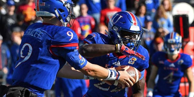 Nov 12, 2016; Lawrence, KS, USA; Kansas Jayhawks quarterback Carter Stanley(9) hands the ball off to running back Ke'aun Kinner (22) against the Iowa State Cyclones during the second half at Memorial Stadium. Mandatory Credit: Peter G. Aiken-USA TODAY Sports