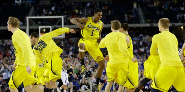 March 29, 2013: Michigan's Glenn Robinson III (1) and teammates celebrate after beating Kansas 87-85 in overtime of a regional semifinal game in the NCAA college basketball tournament in Arlington, Texas.