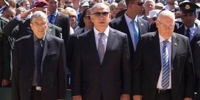Israeli Prime Minister Benjamin Netanyahu, center, Israeli president Reuven Rivlin, right, and Chairman of the Yad Vashem Avner Shalev stand during a sirens as part of a ceremony marking the annual Holocaust Remembrance Day at the Yad Vashem Holocaust memorial, in Jerusalem, Thursday, May 5, 2016. (AP Photo/Dan Balilty)