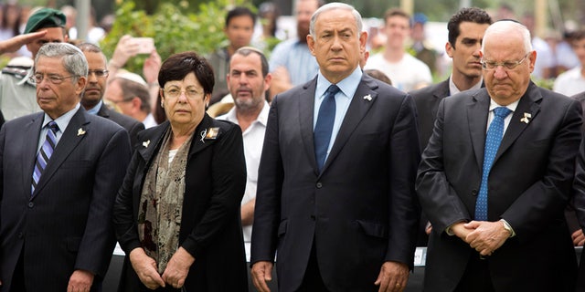 May 11, 2016: Israeli Prime Minister Benjamin Netanyahu (center) stands with President Reuven Rivlin during an official state Memorial Day service for the country’s fallen soldiers and victims of terrorism with a two minute siren during a ceremony held on Mount Herzl Cemetery.