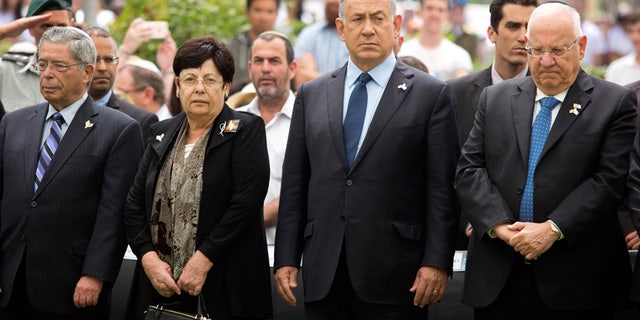 May 11, 2016: Israeli Prime Minister Benjamin Netanyahu (center) stands with President Reuven Rivlin during an official state Memorial Day service for the country’s fallen soldiers and victims of terrorism with a two minute siren during a ceremony held on Mount Herzl Cemetery.
