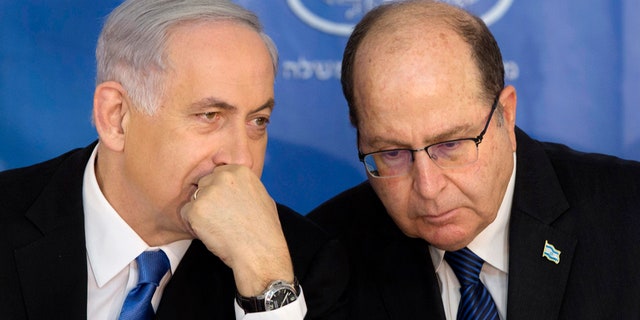 Feb. 16, 2015: Israeli Prime Minister Benjamin Netanyahu, left, speaks with Israel's Defense Minister Moshe Yaalon during a ceremony for new Israeli Chief of Staff Gadi Eizenkot at the Prime Minister's office in Jerusalem.