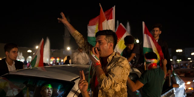 A man with 'yes' shaved into his hair chants through a speaker in the streets of Irbil after polling stations closed on Monday, Sept. 25, 2017. The Kurds of Iraq were voting in a referendum on support for independence that has stirred fears of instability across the region, as the war against the Islamic State group winds down.
