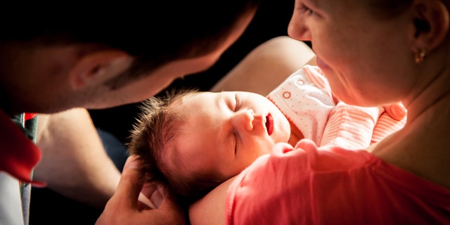 Happy parents holding their newborn baby girl