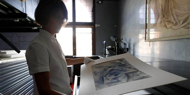July 6, 2012: Francesca Rossi, curator in charge of the Sforzesco Castle drawings collection, looks at a work by Umberto Boccioni, in the same room where sketches by mannerist painter Simone Peterzano are preserved, in Milan.