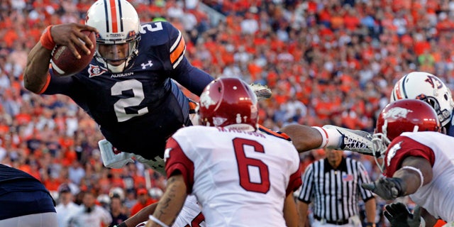 Oct. 16: Auburn quarterback Cameron Newton (2) diving in on for a one-yard touchdown run as Arkansas' Isaac Madison (6) defends during the second half of an NCAA college football game in Auburn, Ala. The Heisman Trophy-winner added AP Player of the Year to his collection of honor on Dec. 22. (AP)