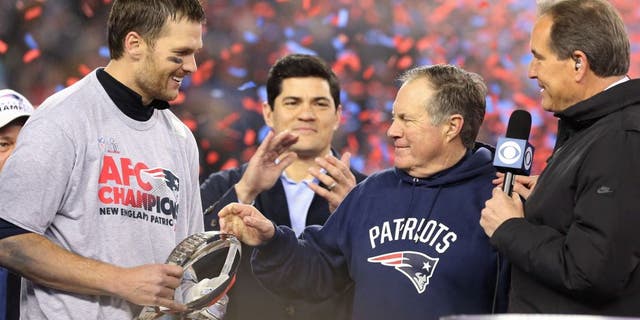 Jan 22, 2017; Foxborough, MA, USA; New England Patriots head coach Bill Belichick (M) hands the Lamar Hunt AFC championship trophy to Patriots quarterback Tom Brady (L) on the victory podium as CBS broadcaster Jim Nantz (R) looks on after the Patriots defeated the Pittsburgh Steelers in the 2017 AFC Championship Game at Gillette Stadium. Mandatory Credit: Geoff Burke-USA TODAY Sports