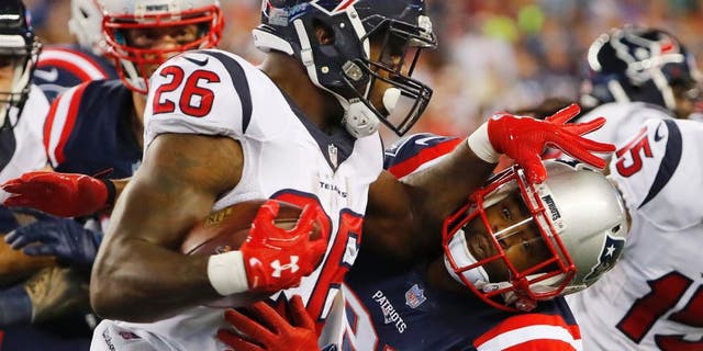 Sep 22, 2016; Foxborough, MA, USA; Houston Texans running back Lamar Miller (26) tries to push away New England Patriots cornerback Malcolm Butler (21) during the first half at Gillette Stadium. Mandatory Credit: Winslow Townson-USA TODAY Sports