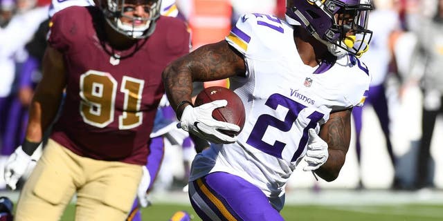 Nov 13, 2016; Landover, MD, USA; Minnesota Vikings running back Jerick McKinnon (21) runs the ball as Washington Redskins linebacker Ryan Kerrigan (91) looks on during the first half at FedEx Field. Mandatory Credit: Brad Mills-USA TODAY Sports