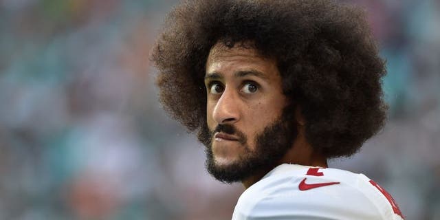 San Francisco 49ers quarterback Colin Kaepernick watches from the sidelines during the Dolphins game in Miami Gardens, Florida, on Nov. 27. 2016.