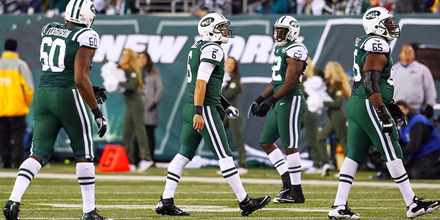 New York Jets quarterback Mark Sanchez (centre) walks off the field after his fumble led to another New England Patriots touchdown during their NFL football game in East Rutherford, New Jersey, November 22, 2012. REUTERS/Gary Hershorn (UNITED STATES - Tags: SPORT FOOTBALL) - TB3E8BN090NTE