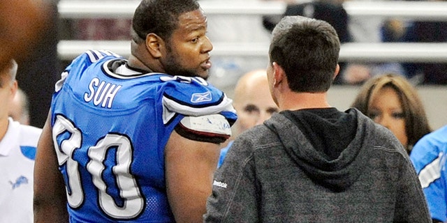 FILE - In this file photo taken Nov. 24, 201, Detroit Lions head coach Jim Schwartz talks with defensive tackle Ndamukong Suh (90) as he leaves the field after being disqualified in the third quarter during an NFL football game against the Green Bay Packers at Ford Field in Detroit. The Packers won 27-15. Suh was ejected from the game after he stepped on a Packers offensive lineman. (AP Photo/The Detroit News, Robin Buckson, File)