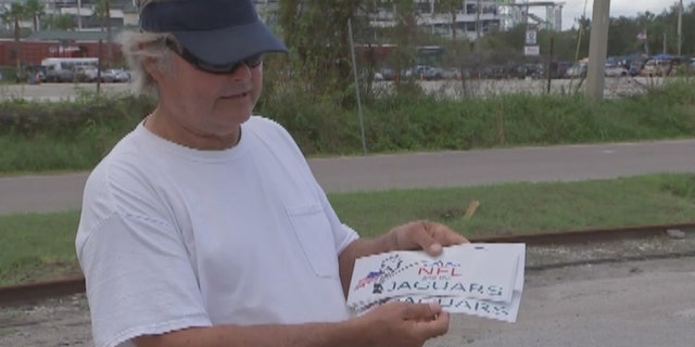 Terry Smiley shows off bumper sticks he's had made after being fed up with national anthem protests.