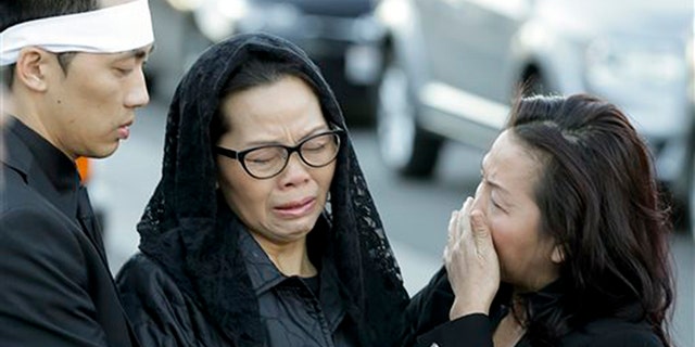 Van Thanh Nguyen, center, arrives for her daughter Tin Nguyen's funeral on Saturday, Dec. 12, 2015 in Santa Ana, Calif. Nguyen died in the mass shootings in San Bernardino, Calif., on Dec. 2. (AP Photo/Chris Carlson)