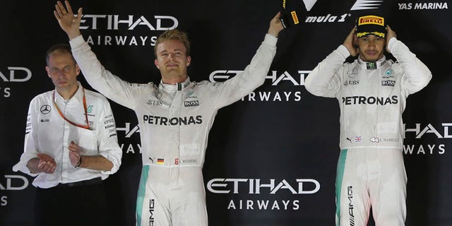 Mercedes driver Lewis Hamilton of Britain, right and Mercedes driver Nico Rosberg of Germany, center, celebrate during the podium ceremony after the Emirates Formula One Grand Prix at the Yas Marina racetrack in Abu Dhabi, United Arab Emirates, Sunday, Nov. 27, 2016. Hamilton took first place in the race with Rosberg finishing second and becoming 2016 world champion. (AP Photo/Kamran Jebreili)
