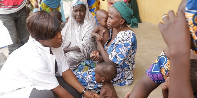 In this Sunday , May. 3, 2015 file photo a doctor attends to a Malnourished child as women and children rescued by Nigerian soldiers wait to receive treatment at a refugee camp in Yola, Nigeria.