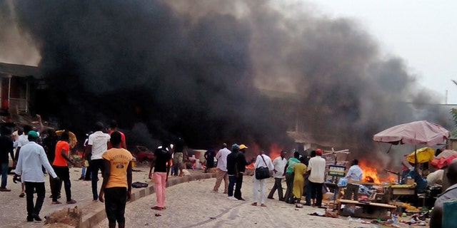 May 20, 2014: Smoke rises after a bomb blast at a bus terminal in Jos, Nigeria.