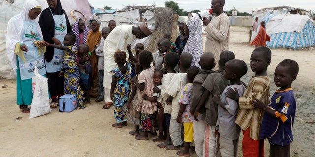 In this photo taken on Sunday, Aug. 28, 2016 health officials administers polio vaccine to children at a camp for people displaced by Islamist Extremist in Maiduguri, Nigeria, Sunday Aug. 28, 2016. Health workers using military helicopters, all-terrain vehicles and tricycle taxis vaccinated hundreds of thousands of children this week, fighting the return of crippling polio in areas newly freed from Boko Haram extremists who violently oppose Western medicine. (AP Photo/Sunday Alamba)