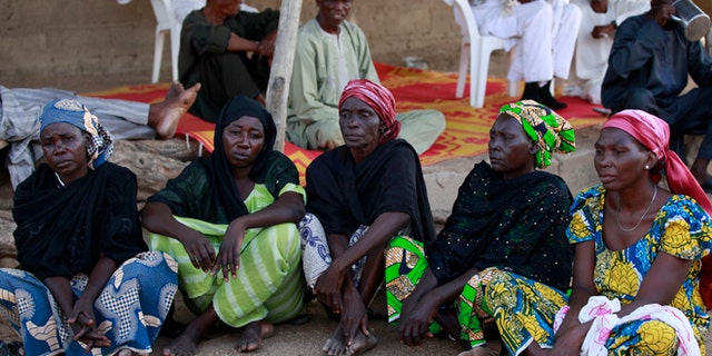 In this Sunday, May 18, 2014 file photo some of the parents of the kidnapped school girls sit outside a compound during a meeting in Chibok, Nigeria. At least 11 parents of the more than 200 kidnapped Nigerian schoolgirls will never see their daughters again. Since the mass abduction of the schoolgirls by Islamic extremists three months ago, at least 11 of their parents have died and their hometown, Chibok, is under siege from the militants, residents report.