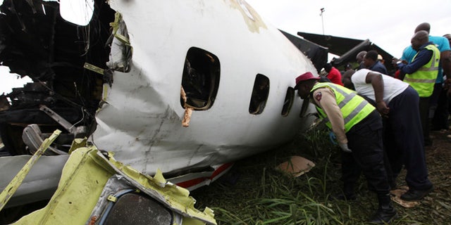 Oct. 3, 2013: Rescue workers peer into the wreckage of a charter passenger jet which crashed soon after take off from Lagos airport, Nigeria. Officials said there were casualties but refused to confirm reports of several deaths.