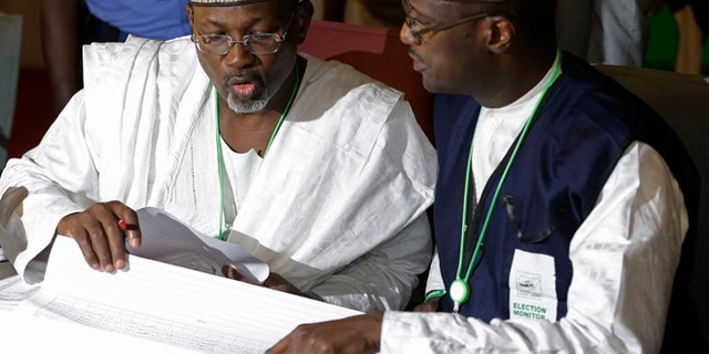 March 30, 2015: Independent National Electoral Commission chairman, Attahiru Jega, left, views election results at the coalition center in Abuja, Nigeria, Monday.