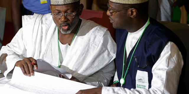 March 30, 2015: Independent National Electoral Commission chairman, Attahiru Jega, left, views election results at the coalition center in Abuja, Nigeria, Monday.