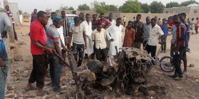 People gather at the site of a suicide bomb attack in Maiduguri, Nigeria Friday, April 27, 2018.