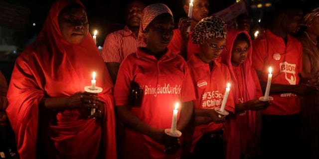 April 14, 2015: People hold candles during a vigil to mark the one year anniversary of the abduction of girls studying at the Chibok government secondary school, Abuja, Nigeria.