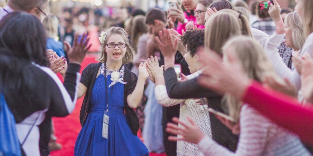 An honored queen goes down the red carpet at a "Night to Shine" from February 10, 2017.