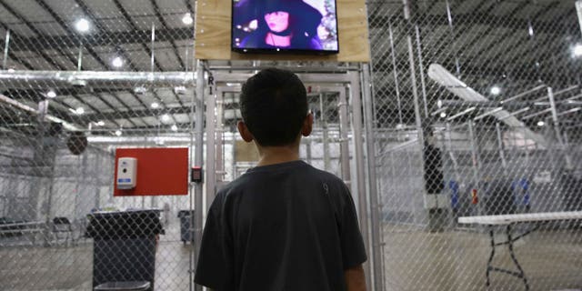 MCALLEN, TX - SEPTEMBER 08: A boy from Honduras watches a movie at a detention facility run by the U.S. Border Patrol on September 8, 2014 in McAllen, Texas. The Border Patrol opened the holding center to temporarily house the children after tens of thousands of families and unaccompanied minors from Central America crossed the border illegally into the United States during the spring and summer. Although the flow of underage immigrants has since slowed greatly, thousands of them are now housed in centers around the United States as immigration courts process their cases. (Photo by John Moore/Getty Images)