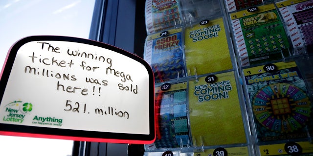 A sign is displayed near scratch-off tickets inside a Lukoil service station where the winning ticket for the Mega Millions lottery drawing was sold, Saturday, March 31, 2018, in Riverdale, N.J.