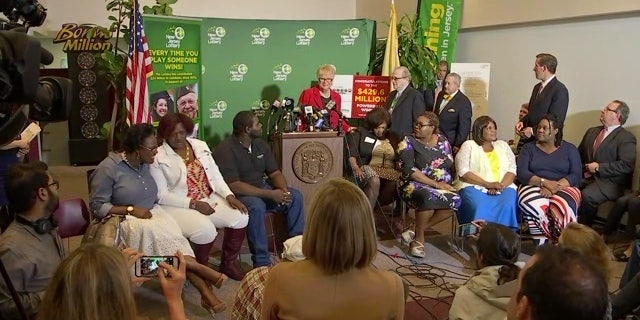 The Smith family with lottery officials at a news conference.