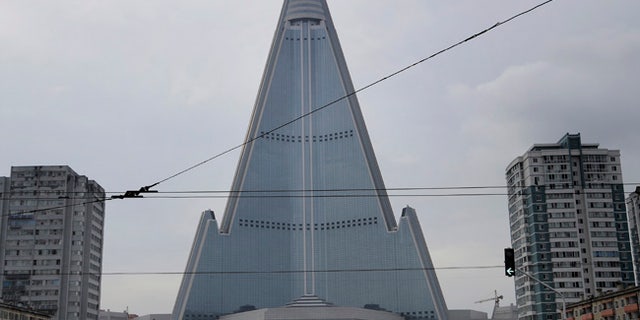 People walk past the 105-story pyramid-shaped Ryugyong Hotel in Pyongyang, North Korea.