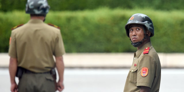 July 27, 2017: North Korean soldiers watch the south side as the United Nations Command officials visit after a commemorative ceremony for the 64th anniversary of the Korean armistice at the truce village of Panmunjom in the Demilitarized Zone (DMZ) dividing the two Koreas.
