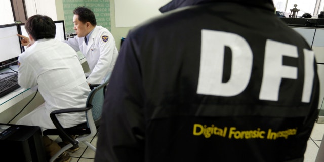 March 21, 2013: South Korean computer researchers, left, check the computer servers of Korean Broadcasting System (KBS) as a South Korean police officer from Digital Forensic Investigation watches at the Cyber Terror Response Center at the National Police Agency in Seoul, South Korea.