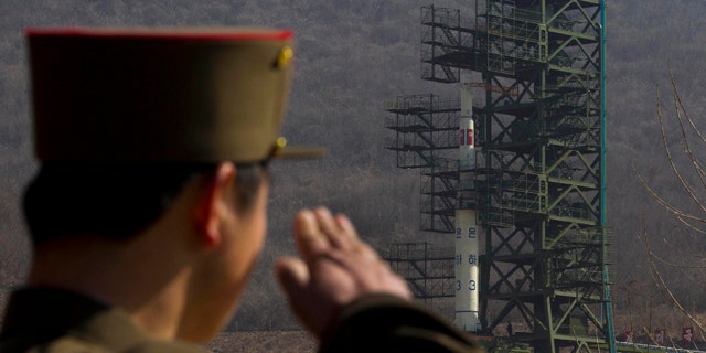 April 8, 2012: In this file photo, a North Korean soldier salutes in front of the country's Unha-3 rocket at Sohae Satellite Station in Tongchang-ri, North Korea.
